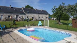 a swimming pool with a toy in a yard at La Maison Neuve Gîtes in Madré