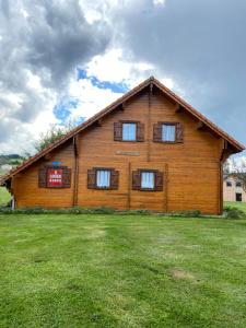 una grande casa in legno con finestre su un campo di Chalet Aster 3 étoiles a Arrentès-de-Corcieux Altre 16 foto