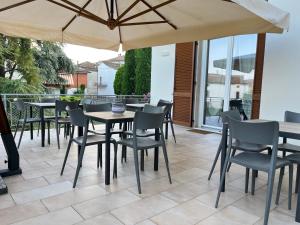 a patio with tables and chairs and an umbrella at I Galli in Agazzano