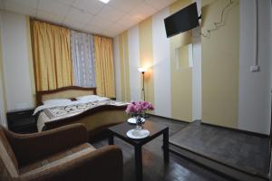 een hotelkamer met een bed en een tafel met bloemen bij Hotel Karat in Moskou