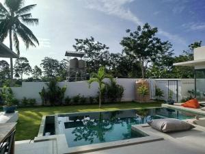 a backyard with a swimming pool and a white fence at Villa Chacha à Lamai in Lamai
