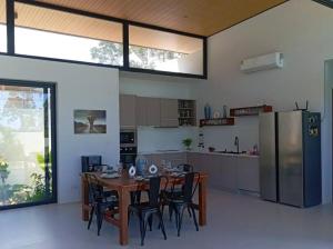 a kitchen with a table and chairs and a refrigerator at Villa Chacha à Lamai in Lamai