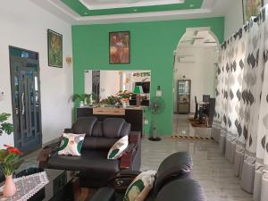 a living room with couches and a green wall at Villa LE HAVRE DE PAIX in Pahou