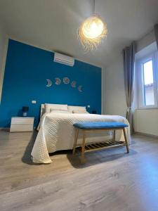 a bedroom with a bed with a blue wall at Luna D'Argento Apartment in Porto Ercole