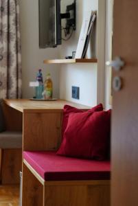 a red pillow sitting on a bench in a room at Gasthof Schweizerhof in Villingen-Schwenningen