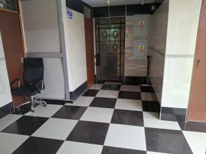 a lobby with a chair and a checkerboard floor at HOSPEDAJE JOVITa in Lima