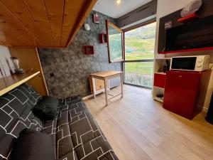 ein Zimmer mit einem Bett, einem Tisch und einem Fernseher in der Unterkunft Orcieres - Studio au pieds des pistes in Orcières