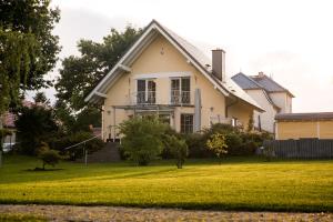 ein weißes Haus mit Rasen davor in der Unterkunft Ferienhaus Seeperle Wendisch Rietz Scharmützelsee in Wendisch Rietz