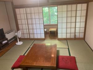 軽井沢町にある余裕堂軽井沢山荘のテーブルとテレビのあるリビングルーム +37枚の写真