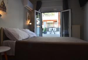 テッサロニキにあるGrey Roomのベッドルーム1室(ベッド1台付)、パティオへのドアが備わります。