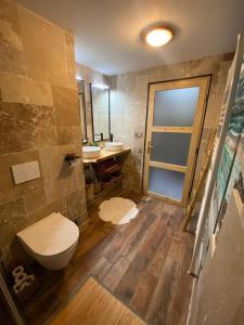 a bathroom with a toilet and two sinks in it at Jolie maison de campagne à la ville chez TINAT in Tregueux