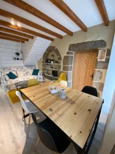 a wooden table in a room with chairs and a couch at Jolie maison de campagne à la ville chez TINAT in Tregueux +9 photos