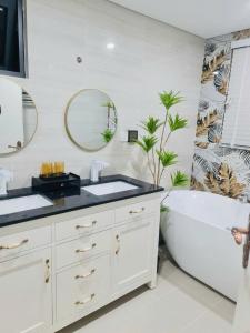 a bathroom with a sink and a tub and a mirror at Dragon Villa 3 Bedroom - Sonasea Vân Đồn Harbor City in Thâm Câu