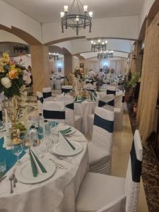 ein langes Esszimmer mit weißen Tischen und Stühlen in der Unterkunft Casa Boiereasca in Iaşi