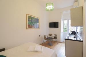 a white kitchen with a table and a small table at Re Di Rhome Guest House in Rome
