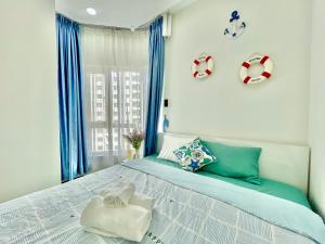 a bedroom with a large bed with blue curtains at 2BR Luxury riverview - Melody of the Sea Monarchy in Da Nang +13 photos
