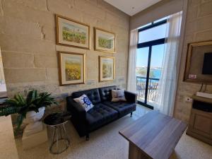 a living room with a couch and a large window at Grand Harbour View in Valletta