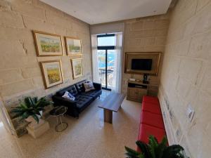 a living room with a couch and a tv at Grand Harbour View in Valletta