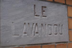 a stone sign on a brick wall with the wordulum at Appartement Le Lavandou in De Panne