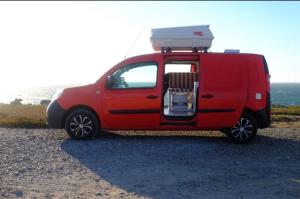 una camioneta roja estacionada al costado de la playa en Surf & love, en Cabanas de Tavira