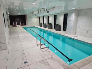a large swimming pool in a building at Urban Retreat - Central Auckland Stay in Auckland