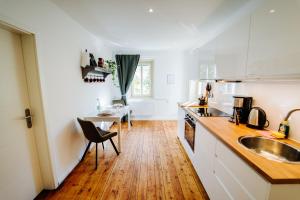 une cuisine avec un évier et une table avec une chaise dans l'établissement Villa Levin 35qm 2Personen mit Pool Wifi und Parken, à Steudnitz