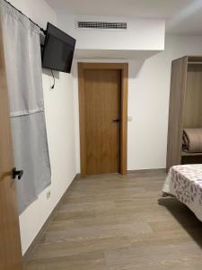 a room with a door and a television on the wall at Apartamentos 7 puentes sierra Cazorla Casa Ciprés in Burunchel