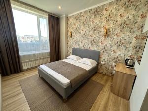 a small bedroom with a bed and a window at Amal Hotel in Astana