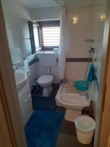 ein Badezimmer mit zwei Waschbecken und einer Toilette und einem Fenster in der Unterkunft Casa Agneza in Medulin