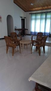 a room with wooden chairs and tables and windows at Sithumina Holiday Home in Diyatalawa