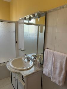 a bathroom with a sink and a mirror at Casa Gonçalves in São Vicente
