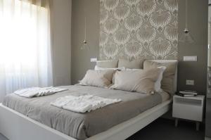 ein großes Bett mit zwei weißen Handtüchern drauf in der Unterkunft Alma Mater B&B in Rom