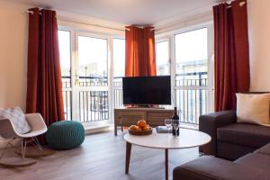 uma sala de estar com um sofá e uma televisão em Boutique Home from Home em Londres