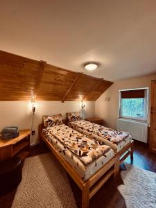 a bedroom with two beds and a wooden ceiling at Cabana Scruba in Topliţa