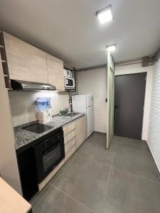 a small kitchen with a stove and a refrigerator at Monoambiente con vista al rio in Posadas +6 photos