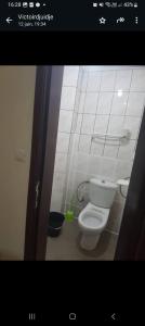 Un baño con un inodoro blanco en una habitación. en Signorile Jo 3, en Yaoundé
