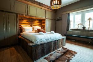 ein Schlafzimmer mit einem großen Bett mit hölzernem Kopfteil in der Unterkunft Oustalet Spa in Spa