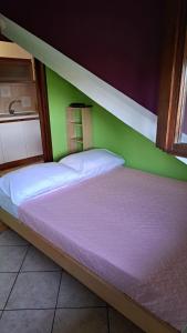 Bett in einem Zimmer mit grüner Wand in der Unterkunft CASA PAOLA - Stazione 400 Mt - free Wifi in Arcore