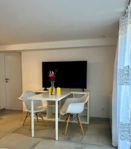 ein Esszimmer mit Tisch und Fernseher in der Unterkunft Football Love in Dortmund