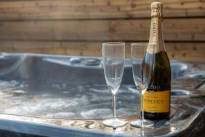 a bottle of champagne and two glasses in a tub at Havana Lodge - Still Rabbit - Hot Tub - Yorkshire in York