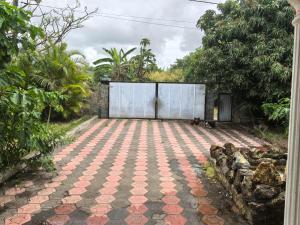 a courtyard with a gate and a tiled floor at Soothing home in Brisée Verdière