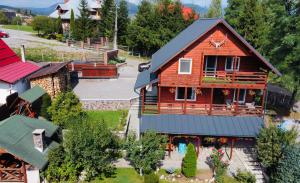 an aerial view of a wooden house with a yard at Cabana Scruba in Topliţa