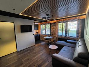 a living room with a couch and a table at Apartament WROTA DO PUSZCZY Z SAUNĄ in Hajnówka