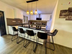 a kitchen with a bar with chairs around it at Villa Esthera RDC in Antsiranana