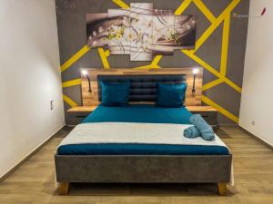 a bedroom with a bed with blue sheets and yellow accents at Villa Esthera RDC in Antsiranana +20 photos