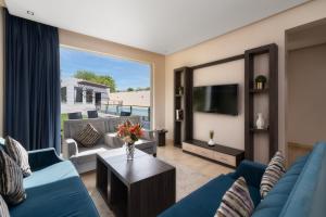 un salon avec un canapé bleu et une télévision dans l'établissement The Corner Hotel Resorts - Riyadh, à Riyad