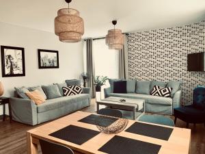 a living room with two couches and a table at Castle Apartments Malbork in Malbork