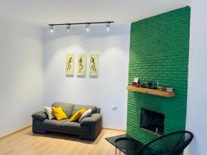 a living room with a couch and a green brick wall at Art Hotel Tabidze in Tbilisi City