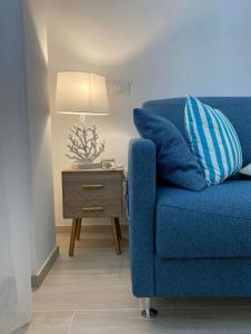 a blue chair sitting next to a side table with a lamp at Casa Vacanze Cimo Marine Style in Civitanova Marche