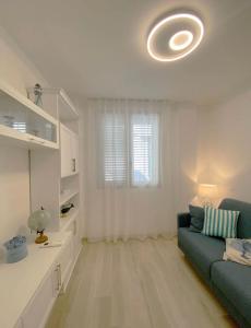 a living room with a green couch and a kitchen at Casa Vacanze Cimo Marine Style in Civitanova Marche